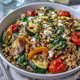 Farro Pasta Bowl with colorful sautéed vegetables and zesty lemon-oregano dressing in a serving bowl.