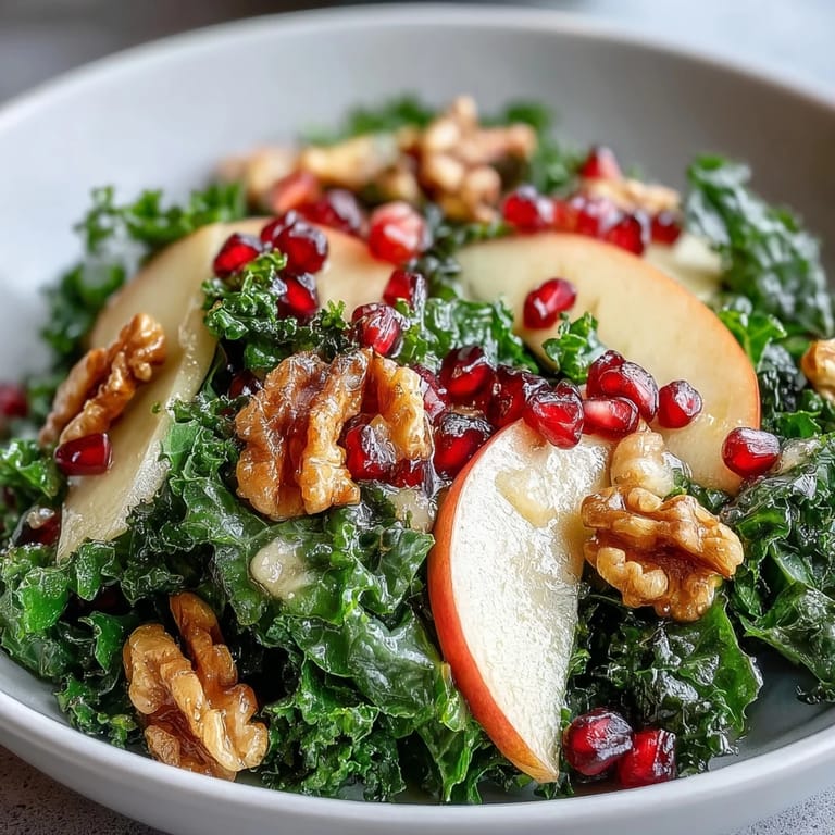 A close-up of the Kale and Pomegranate Bowl topped with walnuts and apple slices, ready to serve as a colorful vegetarian side dish.